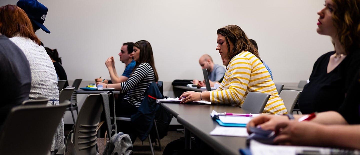 students seated at desks with note pads